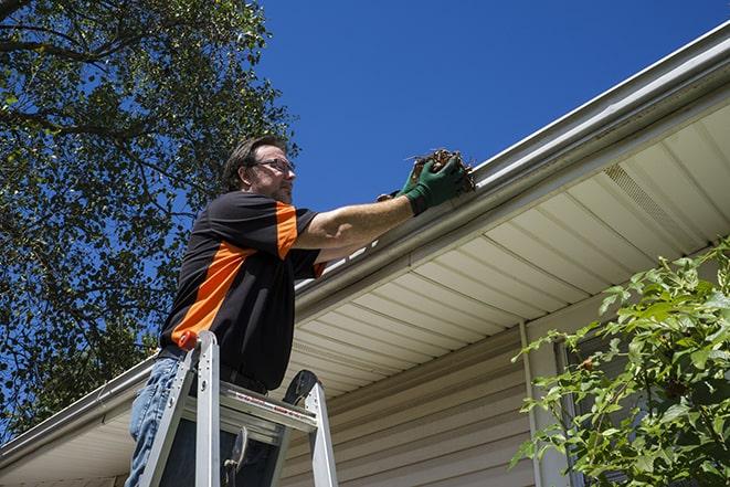 fixing a leaking gutter with professional repair tools in Boxborough, MA